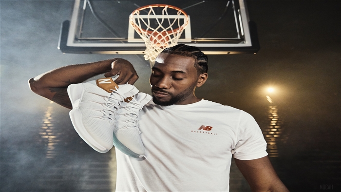 Kawhi Leonard holding New Balance basketball shoes