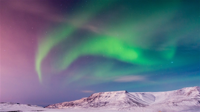 Aurora Borealis over snowy mountains in Iceland 4K