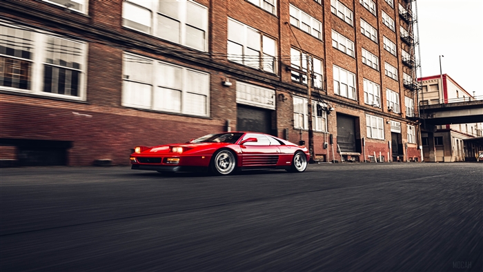 Red Ferrari 348 driving down an urban street