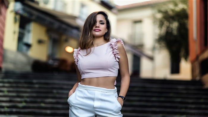 Woman in pink crop top and white pants