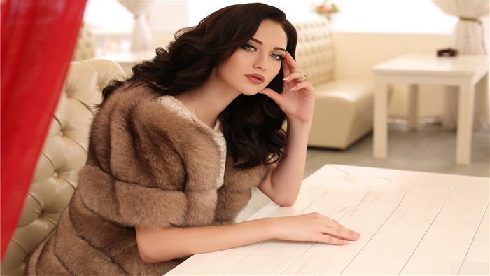 Woman in fur coat sitting at table