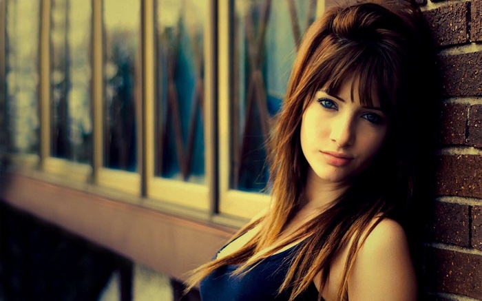 Susan Coffey leaning against a brick wall