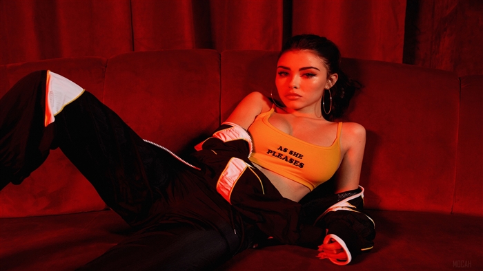 Madison Beer in yellow crop top and black tracksuit
