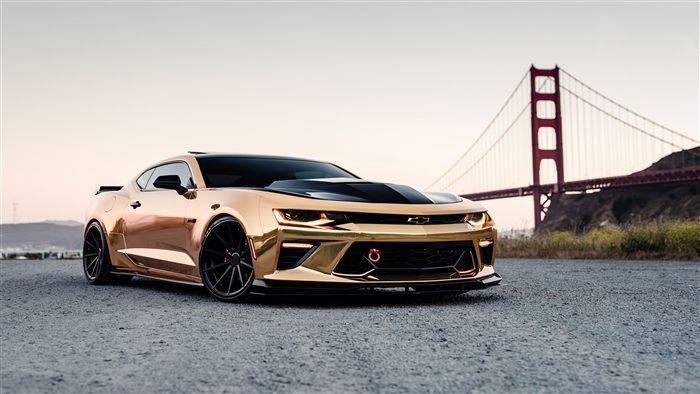 Gold Chevrolet Camaro in front of Golden Gate Bridge