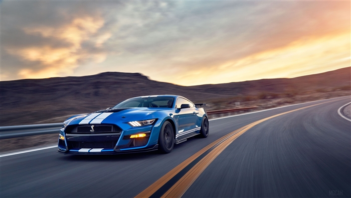 Blue Ford Mustang Shelby GT500 driving on a road