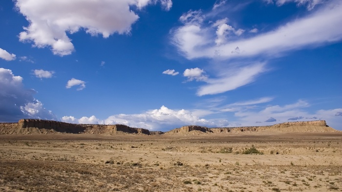 Desert landscape with mesas and clouds
