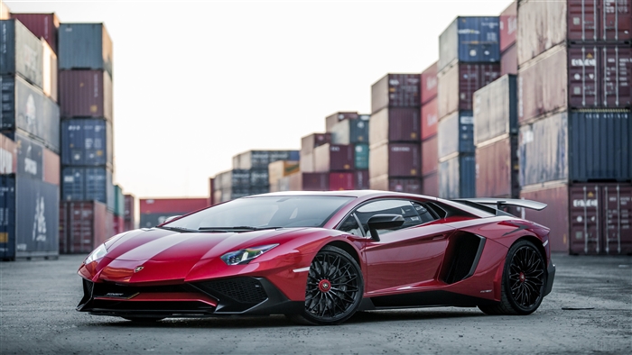 Red Lamborghini Aventador parked near shipping containers