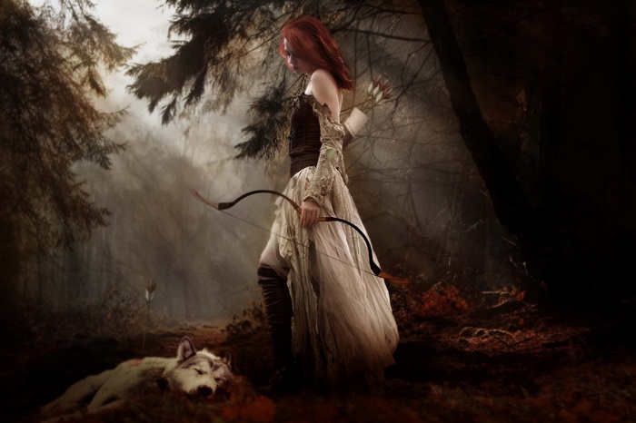 Redhead archer with bow and arrow in foggy woods next to a wolf