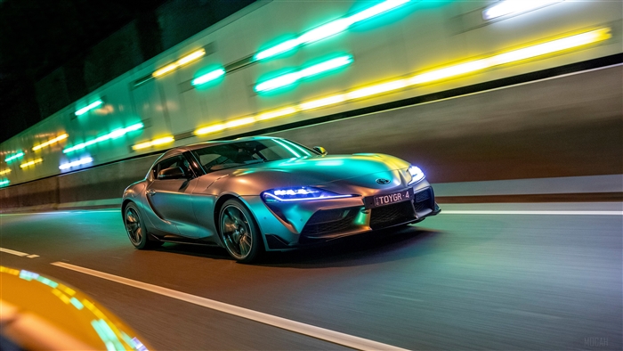 Toyota GR Supra GTS driving through a tunnel with colorful lights