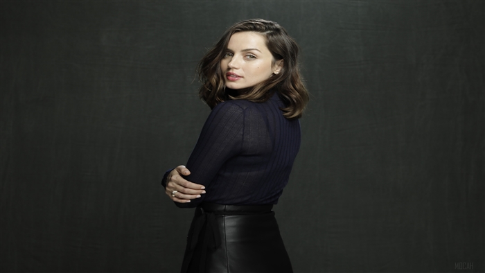 Ana De Armas in a dark blue top and black skirt