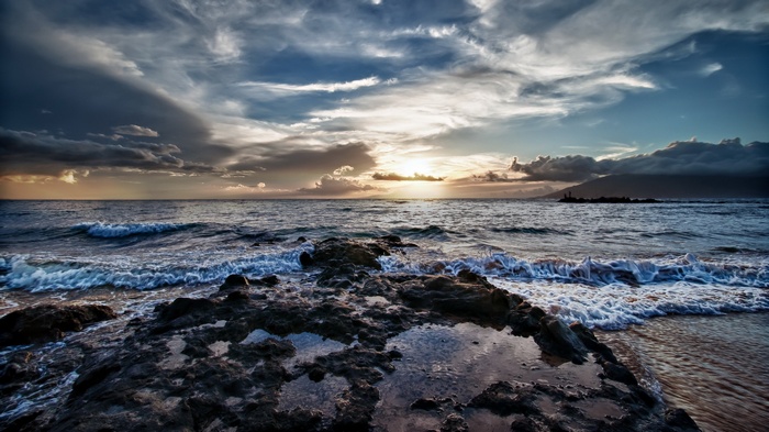 Rocky shore with waves crashing at sunset