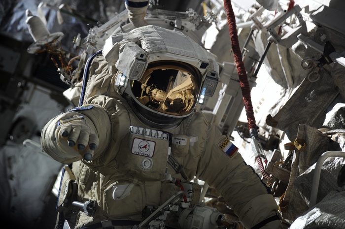 Astronaut in a spacesuit with Roscosmos and Russian flag patches