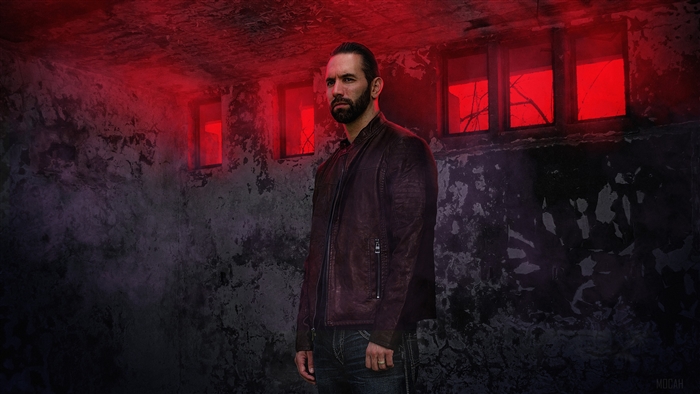Man in leather jacket in abandoned building with red light