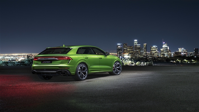 Green Audi RS Q8 at night with city skyline