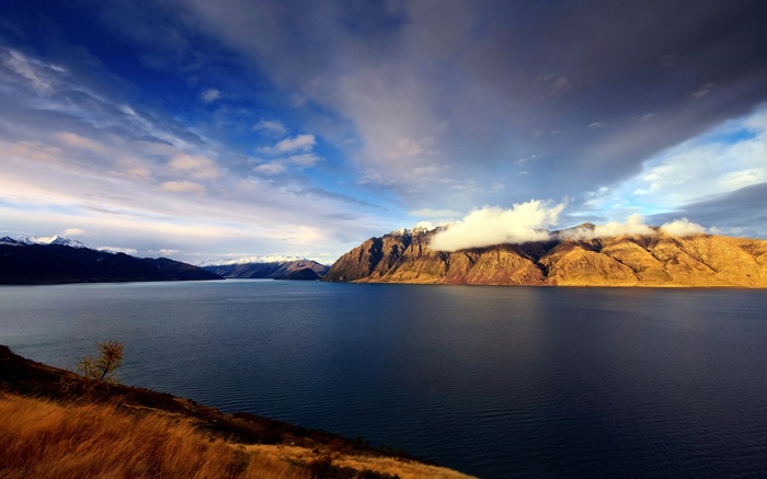 Lake and mountains under a cloudy sky