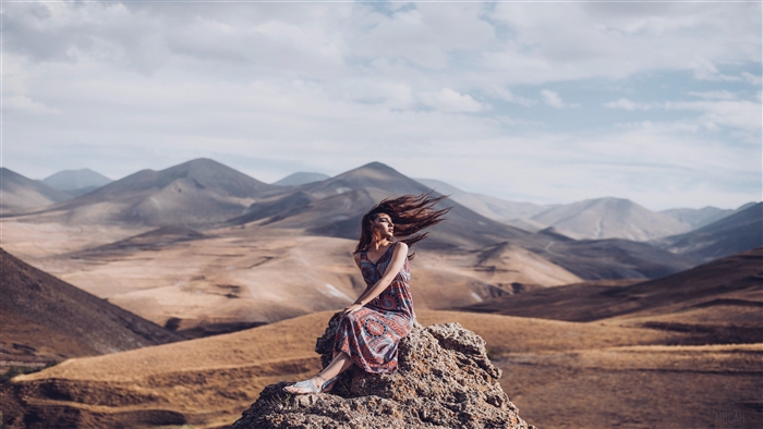 Girl Sitting on Rock with Hair in Air 4K