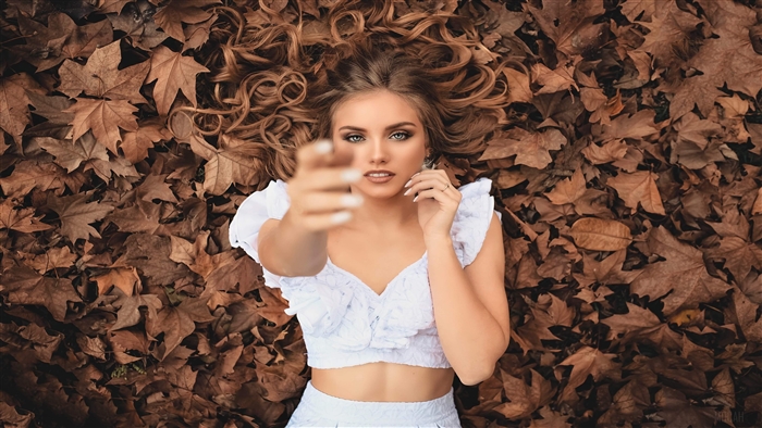 Girl lying on autumn leaves bed 4K