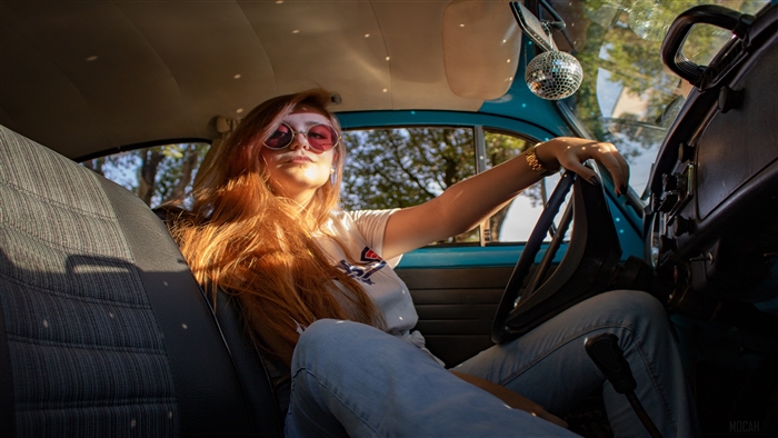 Woman with red hair driving a car