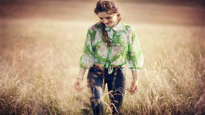 Girl in a field walking and smiling 4K
