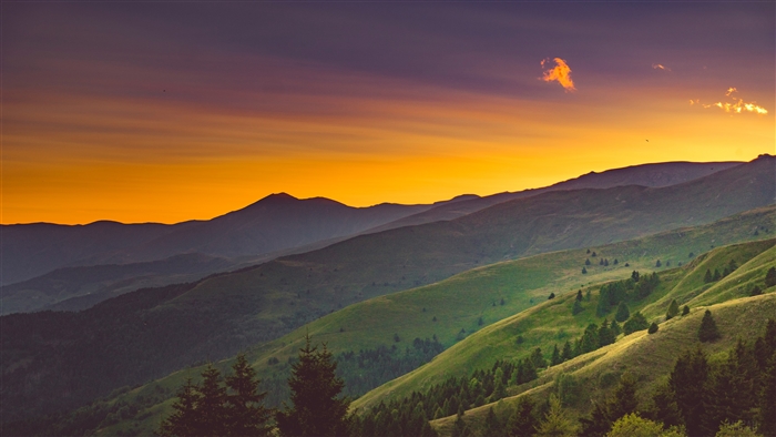 Mountain range at sunset with orange sky