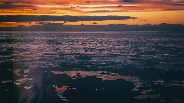 Sunset over the sea with rocky shore