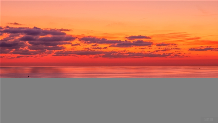 Sunset over a calm lake with clouds