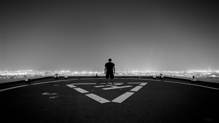 Man Standing on Helipad at Night