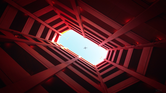 Airplane flying through red architectural building 4K