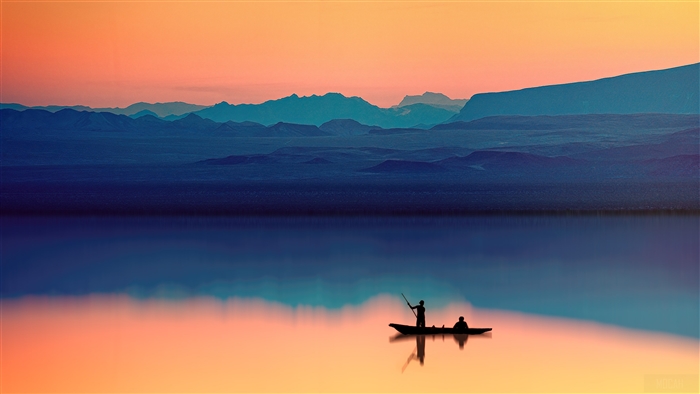 Boat with two people on a lake at sunset