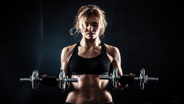 Woman lifting dumbbells in a gym 4K