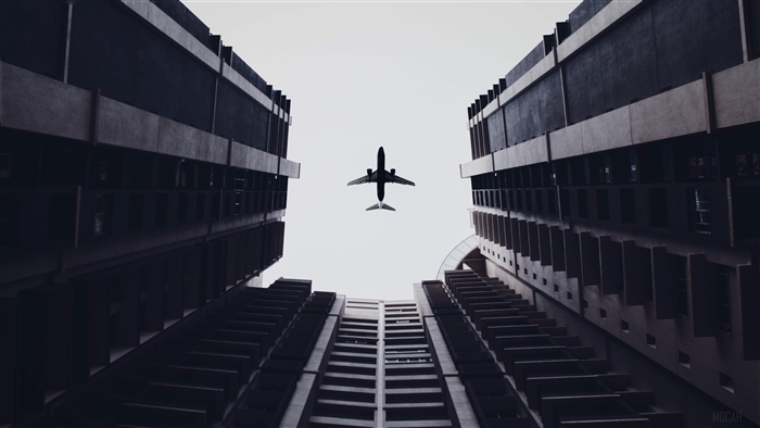 Airplane flying between buildings 4K