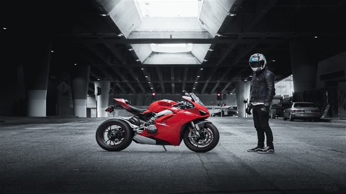 Red Ducati motorcycle with rider under overpass
