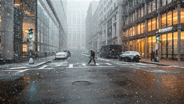 Person walking in snow on a city street 4K