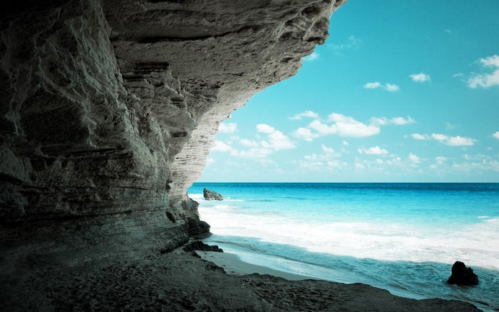 Cave opening to a tropical beach and ocean