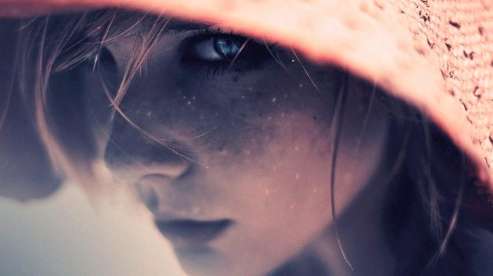 Close-up of a woman with freckles wearing a hat