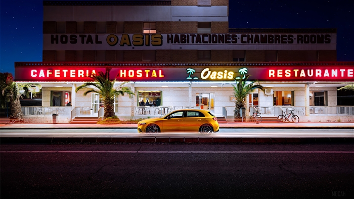 Yellow Mercedes-Benz A35 AMG parked in front of a motel at night