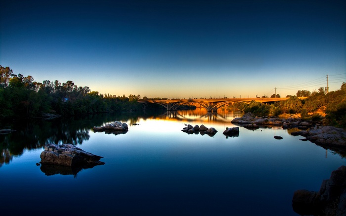 Bridge over a calm river at sunset