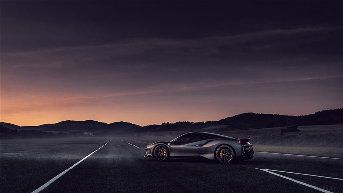Ferrari on a road at sunset