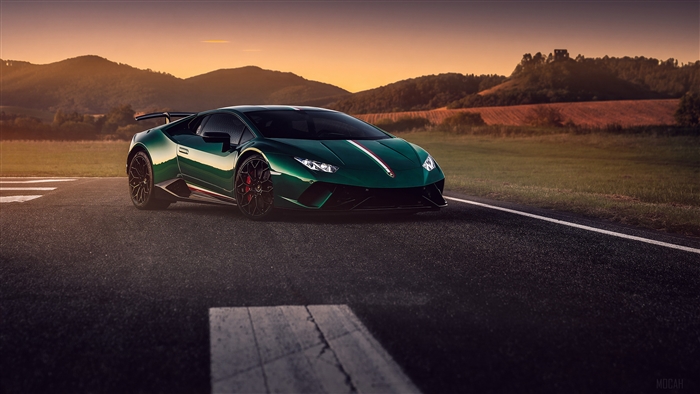 Green Lamborghini Huracan on a road at sunset