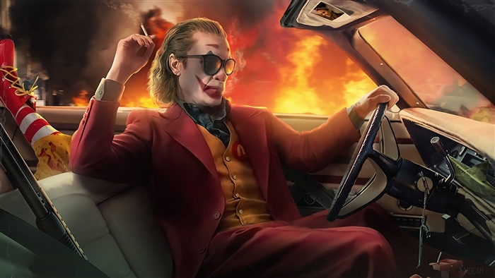 Joker driving a car with fire in the background