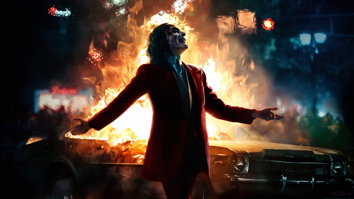 Joker in front of a burning car