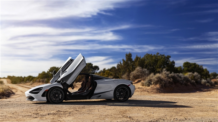 White McLaren 720S Coupe with doors open on dirt road