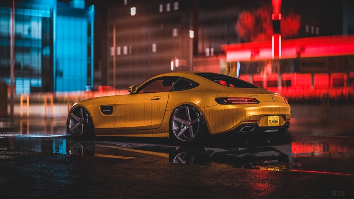 Yellow Mercedes AMG on wet city street at night