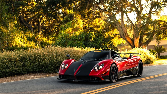 Red and black Pagani Zonda driving on a road