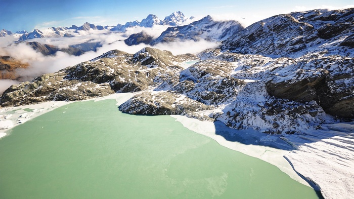 Turquoise glacial lake surrounded by snow-capped mountains