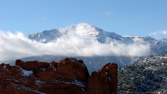 Snow-capped mountains behind red rock formations