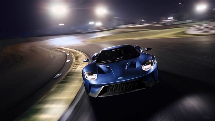 Blue Ford GT driving on a race track at night