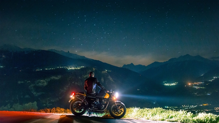 Man on motorcycle on mountain side at night