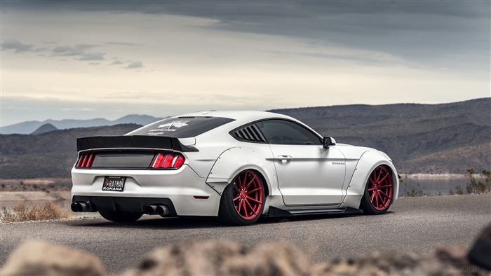 White Ford Mustang GT with widebody kit and red wheels