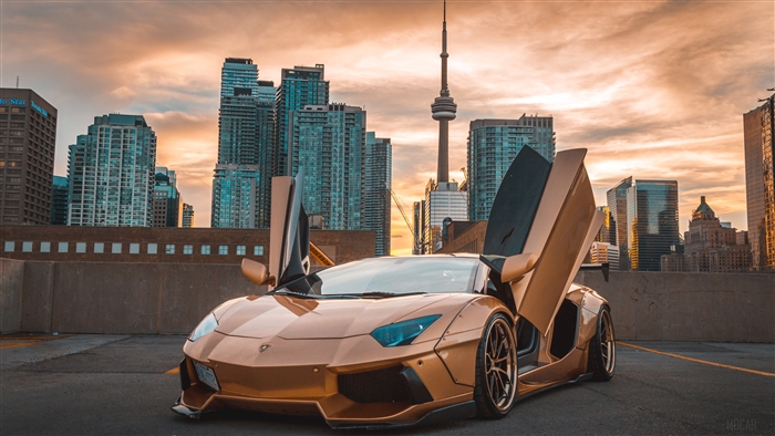 Gold Lamborghini Aventador with CN Tower in background